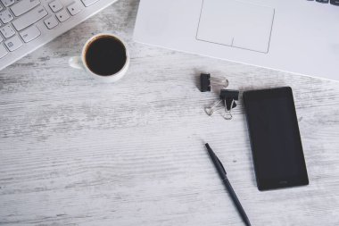 Masasında bilgisayar olan bir fincan kahve.