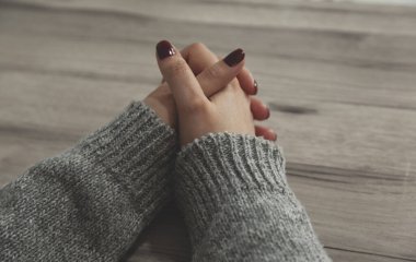 Dua eden kadın elleri masanın arkasında.