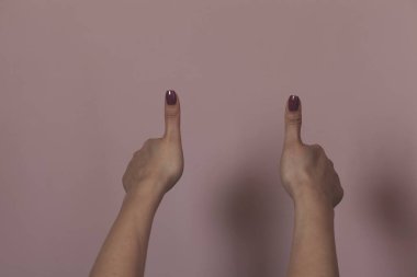Pembe arka planda el parmağı olan kadın.