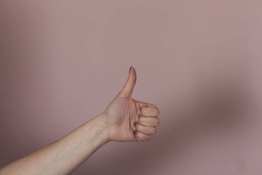 Pembe arka planda el parmağı olan kadın.