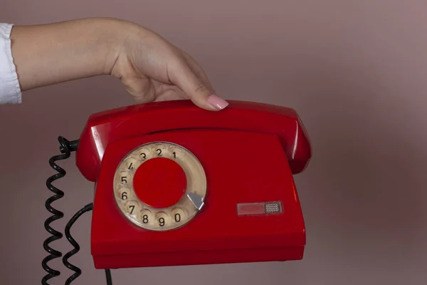 Vrouw Hand Houden Rode Vintage Telefoon Roze Achtergrond — Stockfoto