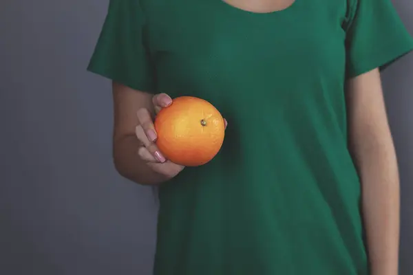 Mujer Mano Sosteniendo Naranja Sobre Fondo Gris — Foto de Stock