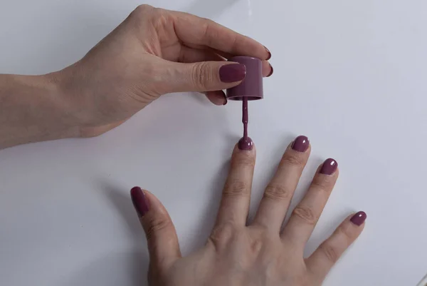 woman hand nail varnish on the desk