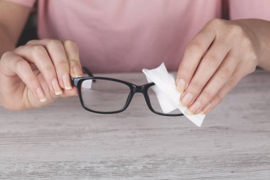 El kadını, gözlüklerini temiz gözlüklerle temizliyor.