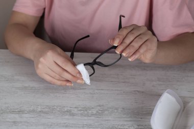 El kadını, gözlüklerini temiz gözlüklerle temizliyor.