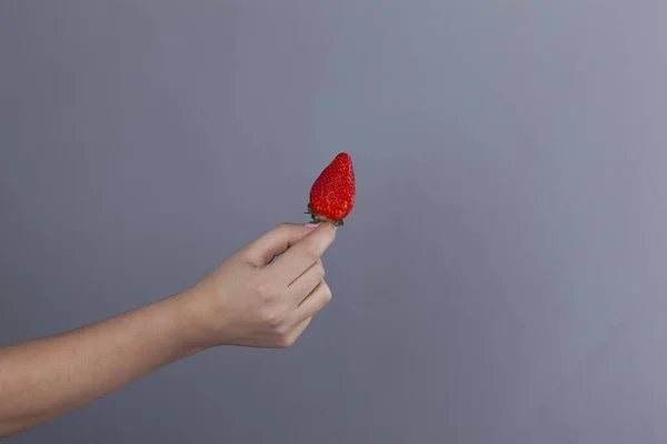 Mano Mujer Sosteniendo Fresa Sobre Fondo Gris — Foto de Stock