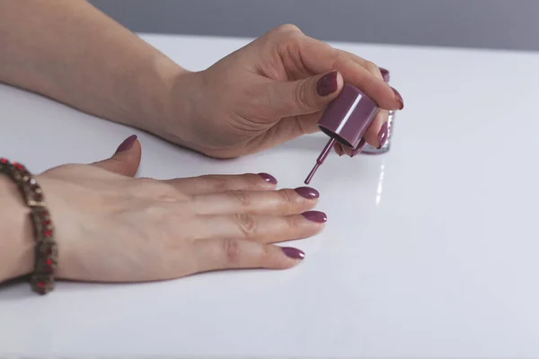 woman hand nail varnish on the desk