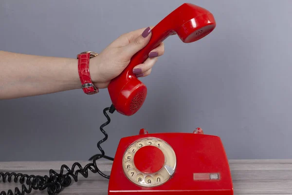 Vrouw Hand Houden Rode Vintage Telefoon Grijze Achtergrond — Stockfoto