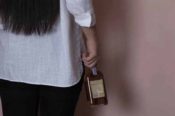 Женщина Держит Бутылку Бренди Розовом Фоне — стоковое фото