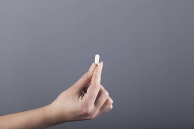 Kadın el hapları gri duvar arkasında