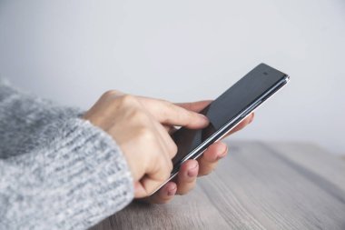 Kadın el akıllı telefonu masanın üstünde.