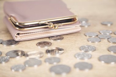 Ahşap masada cüzdanı olan sikkeler.