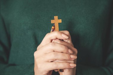 Kadın ahşap haç yeşil arka planda