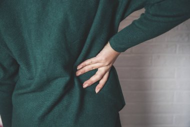 Genç kadın sırtı ağrıyan eller