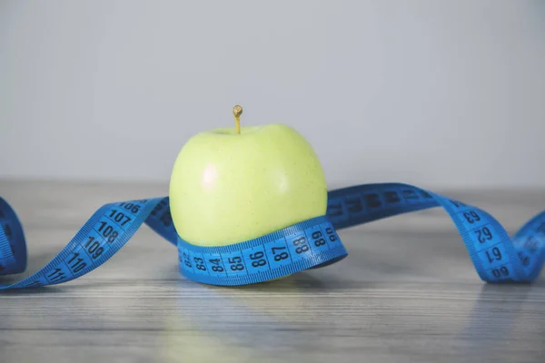 apple in meter on the wooden background
