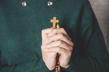 Genç dua eden kadın eli ahşap haç tutuyor