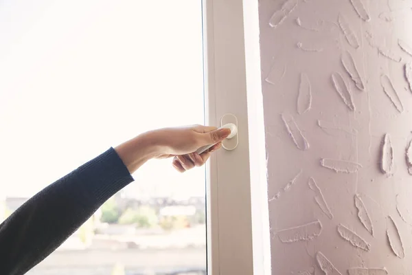 young woman hand opening the window door