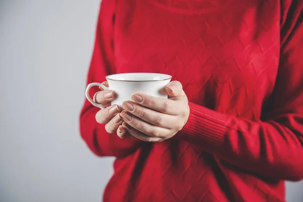 woman hand cup of coffee or tea on gray background