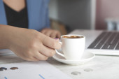 žena ruční šálek kávy na kancelářském stole