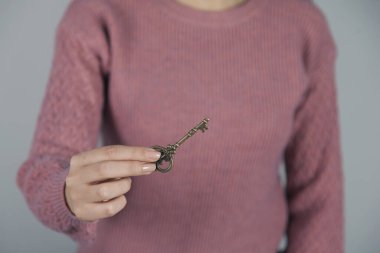 Kadın el ele tutuşma anahtarı gri duvar arka planında