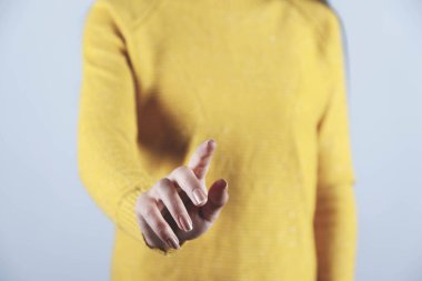 Kadın gri arkaplanda ekrana dokunuyor