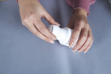 Kadın el ilacı şişesi masanın üstünde.