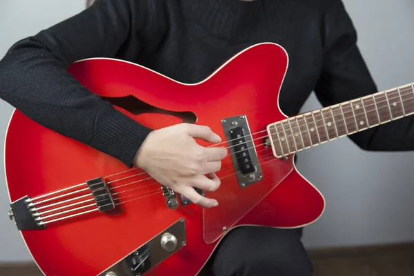 woman hand holding guitar on the dark background