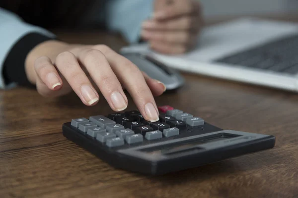 woman hand calculator with computer on the desk