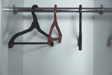 Beyaz gardırop arka planında boş askılar .