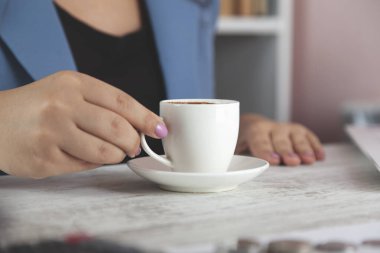 Masasında bilgisayar klavyesi olan kadın el kahvesi.