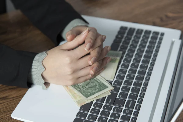 woman hand money on computer keyboard on desk