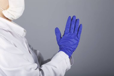 Gri duvar arka planında doktor eli çapraz