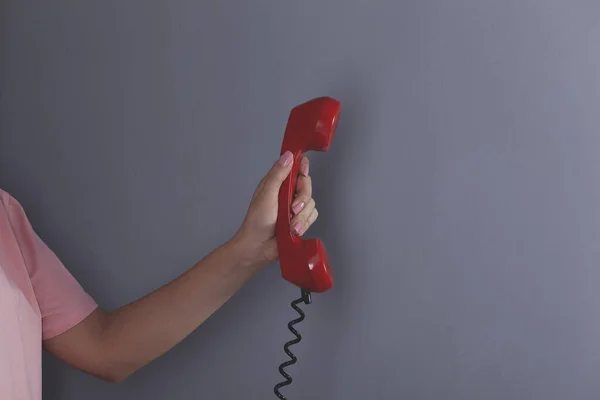 Vrouw Hand Houden Rode Vintage Telefoon Grijze Achtergrond — Stockfoto