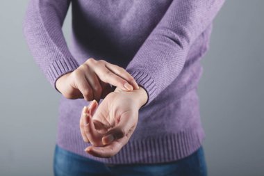 Gri duvar arkasında nabzı atan bir kadın.