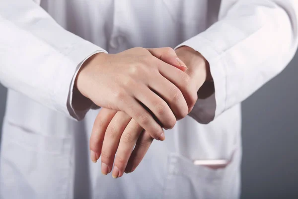 doctor washing hands in gel on grey background
