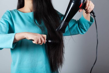 Saç kurutma makinesiyle kadın saç stili.