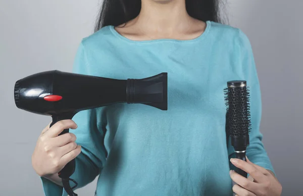 woman hand  hair dryer on the grey wall background