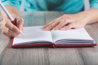 Gri arka planda kadın el kalemi ve not defteri