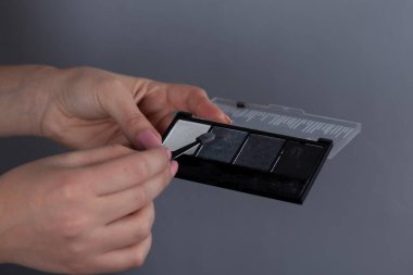 Gri arka planda kadın el makyajı çantası