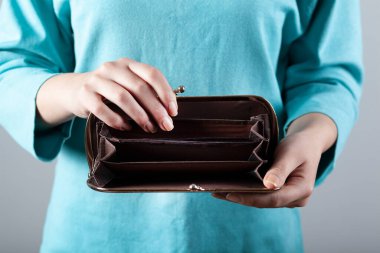 Gri arka planda eli boş bir kadın.