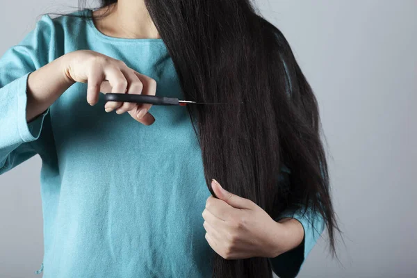 Mujer Cortar Cabello Con Tijeras Sobre Fondo Gris — Foto de Stock