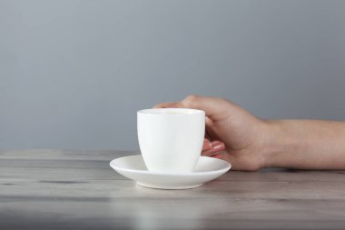 Kadın masada kahve ve leylak içiyor.