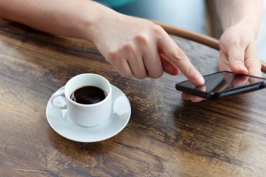  Masasında kahve olan kadın cep telefonu.