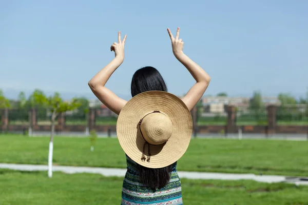 woman hand in hat on green grass background