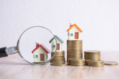 Büyüteç ve bozuk parayla evin minyatürü. ev ve para. Oyuncak ev, büyüteç ve bozuk para. konut kredisi, inşaat, kiralık konut.