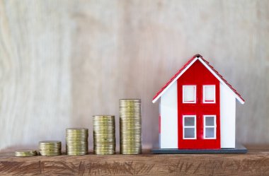 Kırmızı çatı evi modeli. Aşağıdan yukarıya istiflenmiş bozuk paralar. Mali ve bankacılık kavramları ev satın almaya ve gayrimenkul ekonomik büyümesine hazırlanıyor. Ev kredisi.