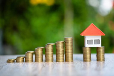 Aşağıdan yukarıya istiflenmiş bozuk paralar. Turuncu çatı katı. Bir yığın bozuk para koy. Konut kredisi, ipotek ve yatırım fikirleri için para biriktirme planları, bir konut için tasarruf veya yatırım.