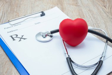 Kırmızı kalp ve tıbbi steteskop doktorun şarj tabağına. Sağlık kontrolü konsepti sağlık sigortası. Sağlık sigortası. Bir doktorun emrettiği gibi kendine dikkat ediyorsun..