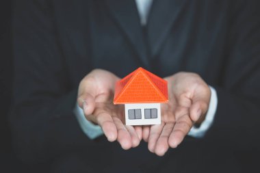 Turuncu çatı yatırımcıların elinde emlak yatırım kavramları, ev, ipotek ve krediler, bankacılık, muhasebe ve vergi tasarrufu ve satın alma