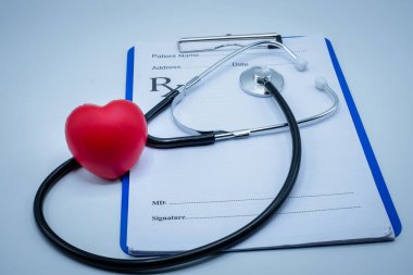 Doktorun şarj tabağına kırmızı kalp medikal steteskop ve siyah kalem koyun. Sağlık kontrolü konsepti. Sağlık sigortası. Bir doktorun emrettiği gibi kendine dikkat ediyorsun..